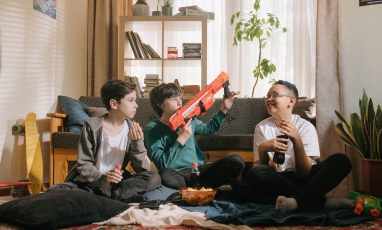 Three kids enjoying a playful and relaxed day inside with snacks and toy guns.