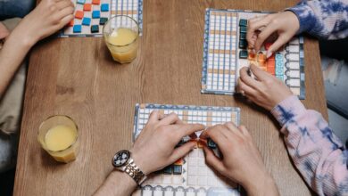 Close-up of hands and board game tiles during a fun gaming session indoors.