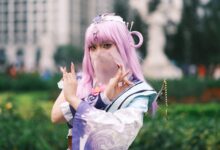 Cosplay enthusiast poses in colorful attire with lavender hair outdoors in Vietnam.