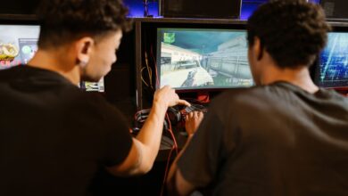 Two young men playing a multiplayer computer game at an arcade with enthusiasm and focus.