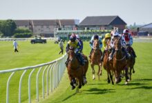 Jockeys compete intensely at the Musselburgh Racecourse in Scotland, showcasing equestrian skill and speed.