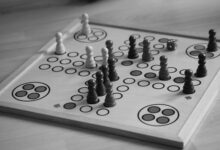 Black and white image of a board game with chess pieces and dice.