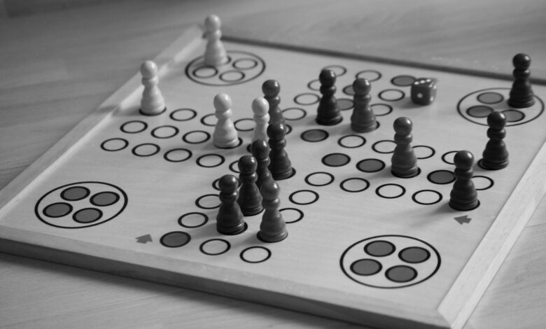 Black and white image of a board game with chess pieces and dice.