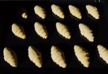 Fresh unbaked croissants aligned on a tray, capturing the essence of baking in progress.