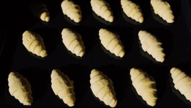 Fresh unbaked croissants aligned on a tray, capturing the essence of baking in progress.