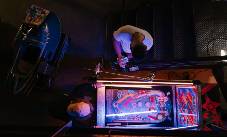 Overhead view of pinball game being set up in a retro arcade setting.
