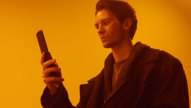 Dramatic studio portrait of a man using a vintage flip phone.