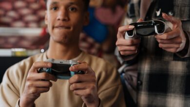 Two young adults intensely focused on playing video games with controllers indoors.