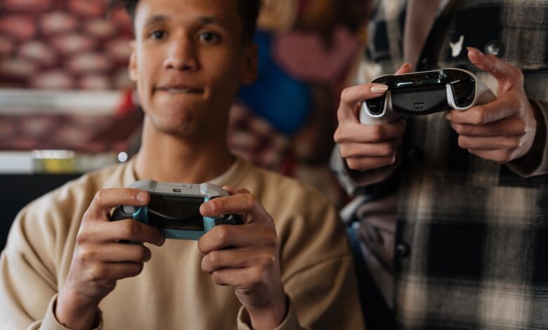 Two young adults intensely focused on playing video games with controllers indoors.