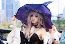 A young woman cosplaying as a witch outdoors, wearing a purple hat and fantasy attire.