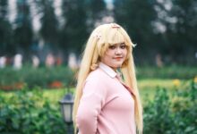 Cosplay enthusiast posing outdoors in a vibrant, lush Vietnamese garden setting.