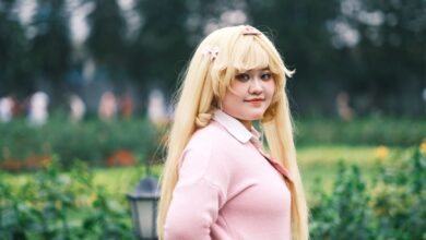 Cosplay enthusiast posing outdoors in a vibrant, lush Vietnamese garden setting.
