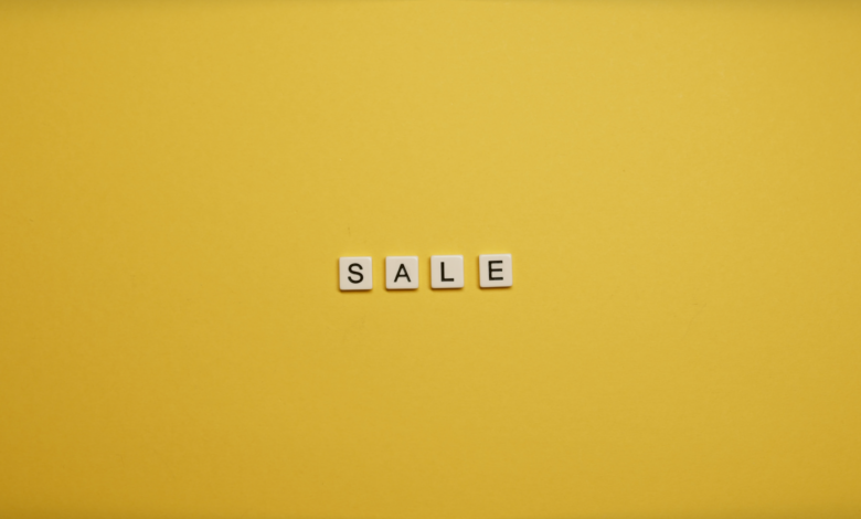 Single word 'SALE' spelled with tiles on a bright yellow background, ideal for advertising.