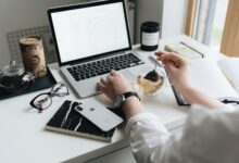 A cozy home office scene with a laptop, tea, and workspace essentials.