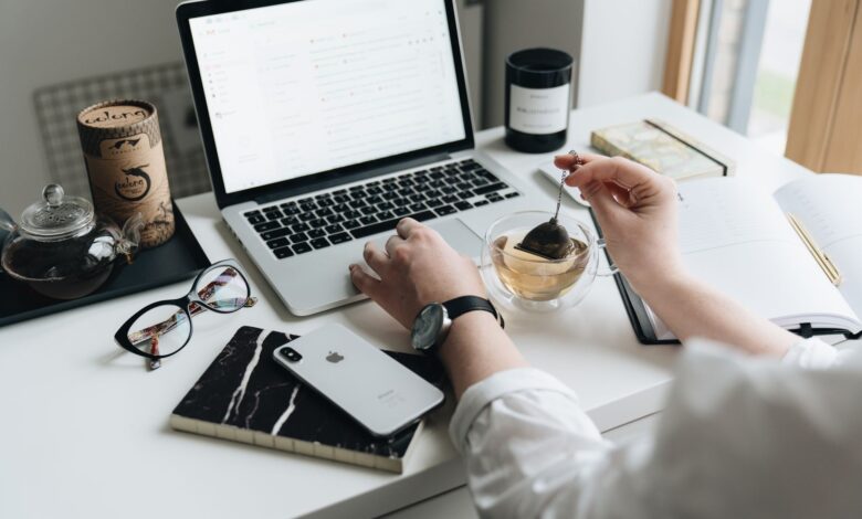 A cozy home office scene with a laptop, tea, and workspace essentials.