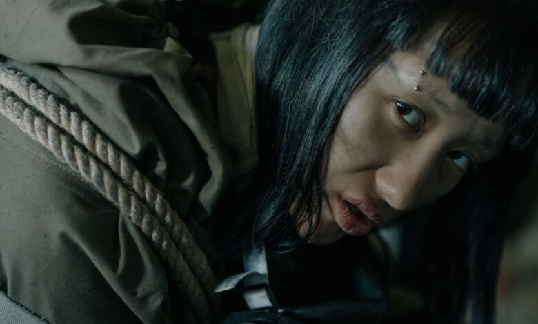 A woman with eyebrow piercing in urban survival gear, conveying a dystopian feel.