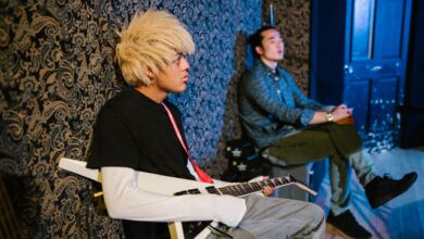 Two young musicians in a studio, featuring an electric guitar and artistic vibe.