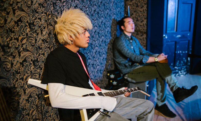 Two young musicians in a studio, featuring an electric guitar and artistic vibe.
