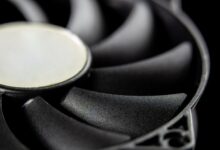 Macro close-up of a modern computer cooling fan blade, showcasing intricate details.