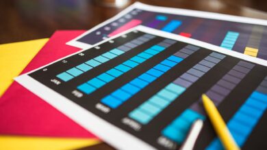 Close-up of colorful financial charts and a pencil on a wooden desk.