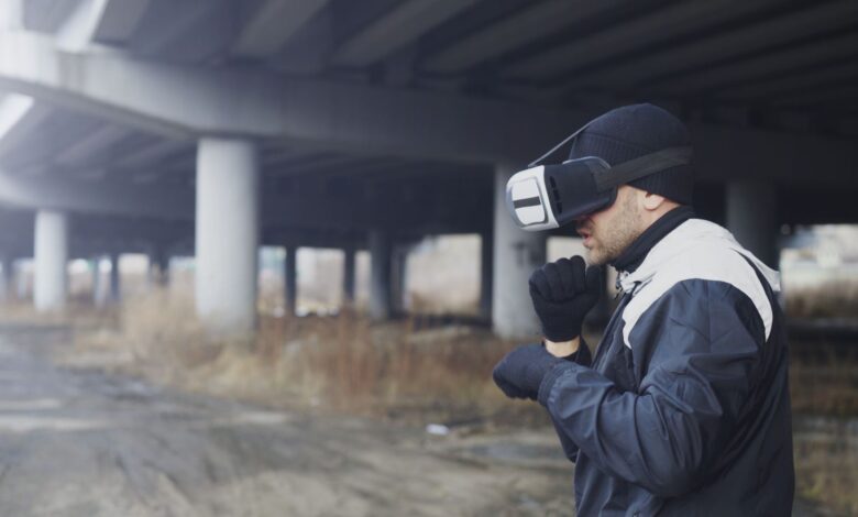 Man wearing VR headset under a bridge, exploring virtual reality outdoors.