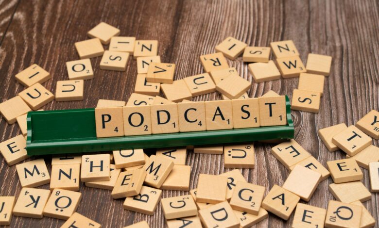 Wooden letter tiles on a board spelling the word 'Podcast', symbolizing digital media and creativity.