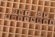 Wooden blocks spelling out 'Out Of Business' symbolize closure or economic downturn.