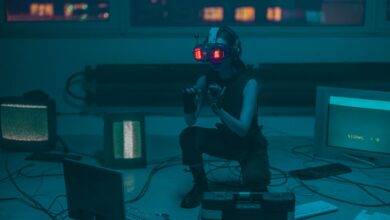 A woman crouching with VR headset in a sci-fi room filled with digital screens.