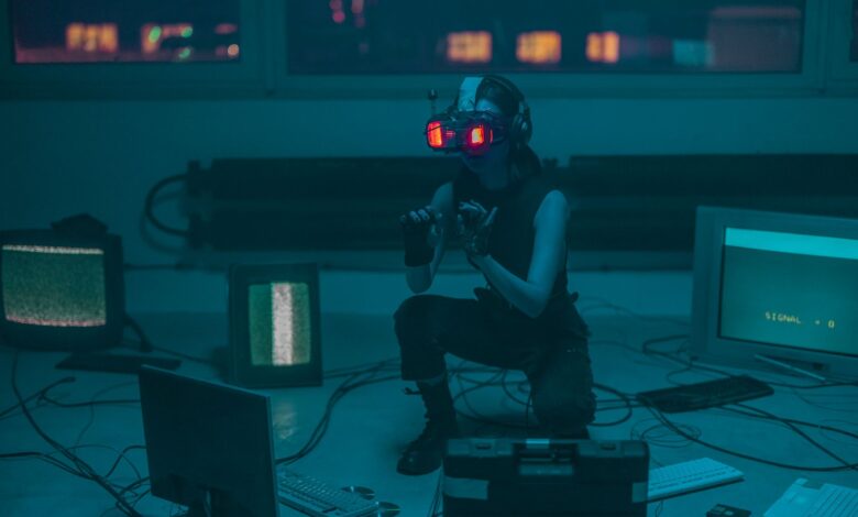 A woman crouching with VR headset in a sci-fi room filled with digital screens.