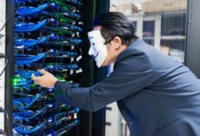 Masked individual interacting with server racks, symbolizing cybersecurity threats.