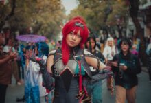 Colorful cosplay character poses at a lively outdoor street festival, showcasing fantasy costume details.