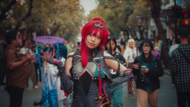 Colorful cosplay character poses at a lively outdoor street festival, showcasing fantasy costume details.