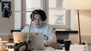 Focused young man working at his desk with a laptop in a contemporary office.