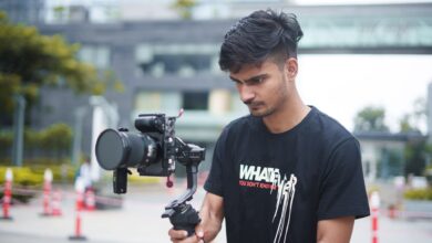 A young filmmaker using a gimbal and camera setup outdoors for dynamic video shooting.