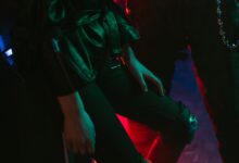 Stylish fashion shot with neon lighting and leather attire, highlighting cyberpunk aesthetics.