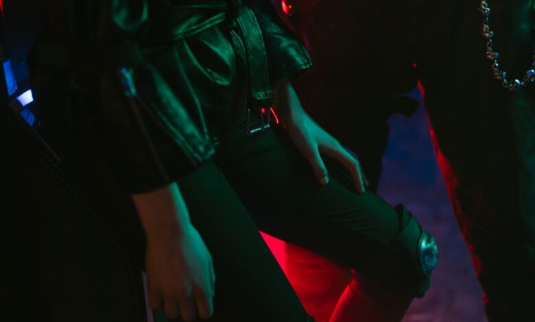 Stylish fashion shot with neon lighting and leather attire, highlighting cyberpunk aesthetics.