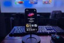 A stylish gaming setup featuring a smartphone on a stand with a vibrant display, keyboard, and mouse.