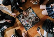 Aerial view of friends enjoying a board game on wooden floor.