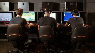 A group of men intensely focused on playing video games at a modern gaming arcade.