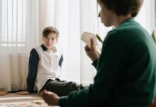 Two kids engaging in a card game indoors, enjoying leisure time and strategic gameplay.