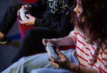 Two young gamers intensely focused while playing video games with modern controllers indoors.