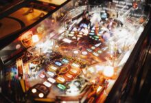 Colorful pinball machine in an arcade setting with bright lights and intricate design.
