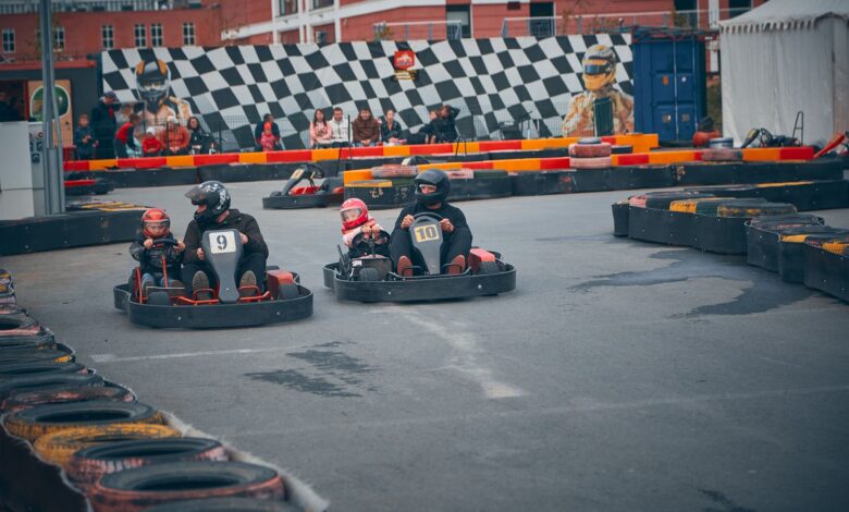 Thrilling outdoor go-kart race with competitors wearing helmets speeding on a track.