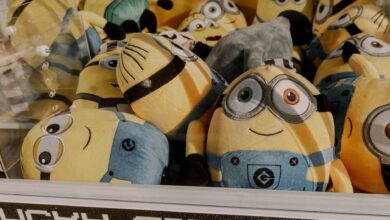 A collection of vibrant minion plush toys inside an arcade claw machine, perfect for entertainment.