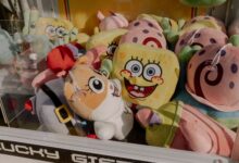 A vibrant claw machine filled with various plush toys at an arcade, offering fun entertainment.