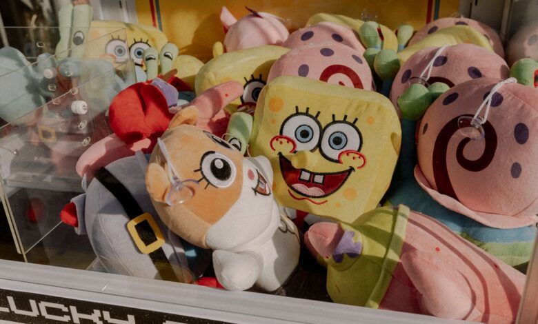 A vibrant claw machine filled with various plush toys at an arcade, offering fun entertainment.
