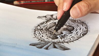 A person skillfully drawing a pufferfish illustration with fine details using a pen.