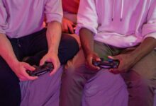 Two friends playing video games together at home, using controllers.