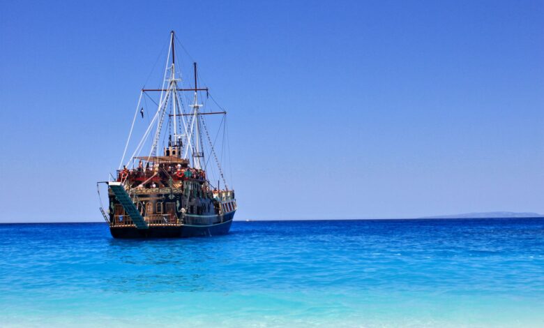 A classic pirate ship anchored near a sandy beach on Zakynthos, Greece.