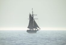 A tranquil silhouette of a sailing ship on a calm sea horizon, evoking peace and adventure.